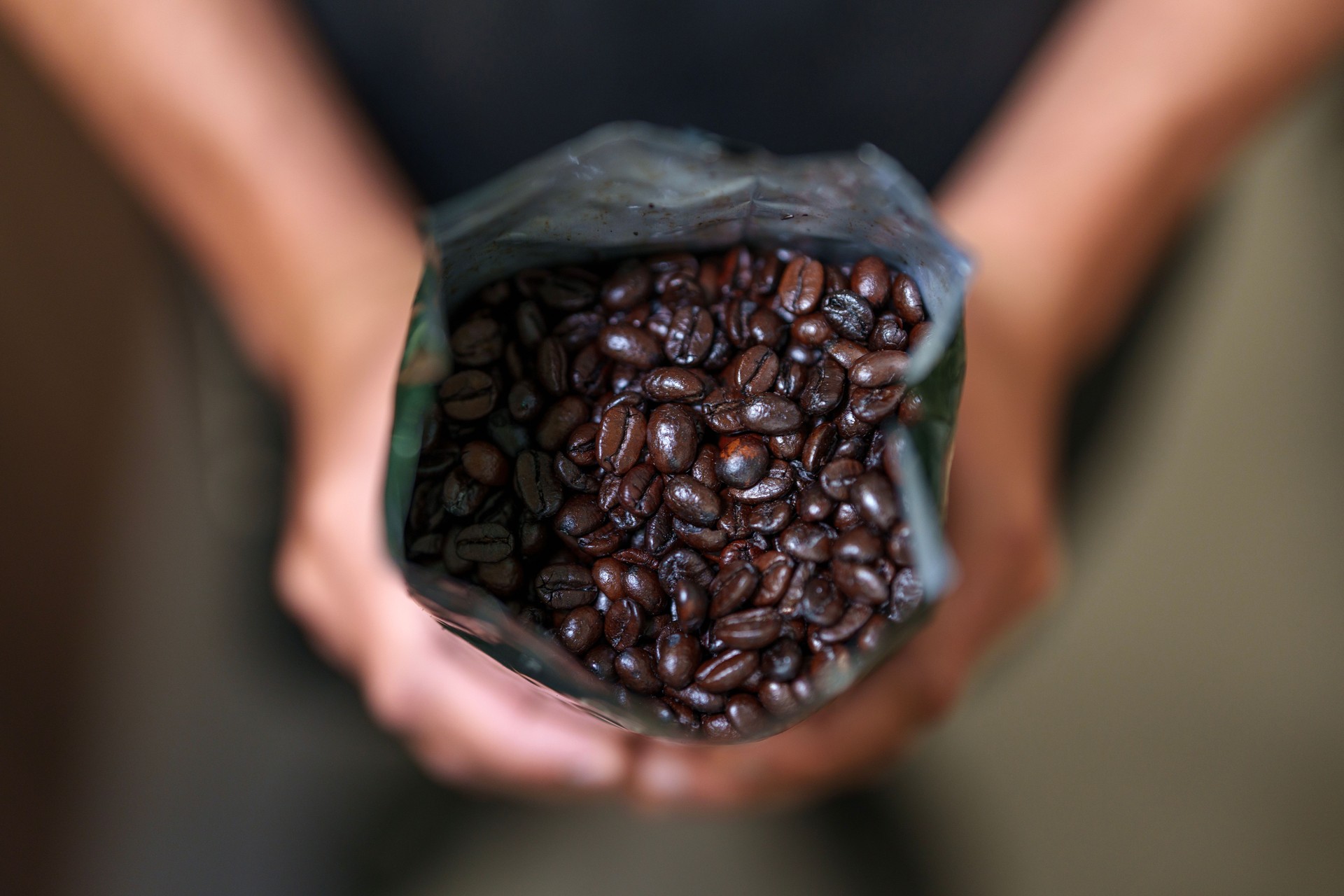 Barista Holding Coffee Bean Bag at Coffee Shop